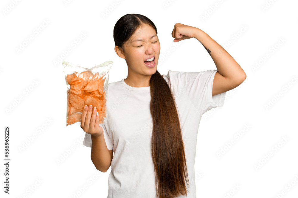 Young asian woman holding crips isolated on green chroma background raising fist after a victory, winner concept. Young asian woman holding crips isolated on green chroma background raising fist after a victory, winner concept.