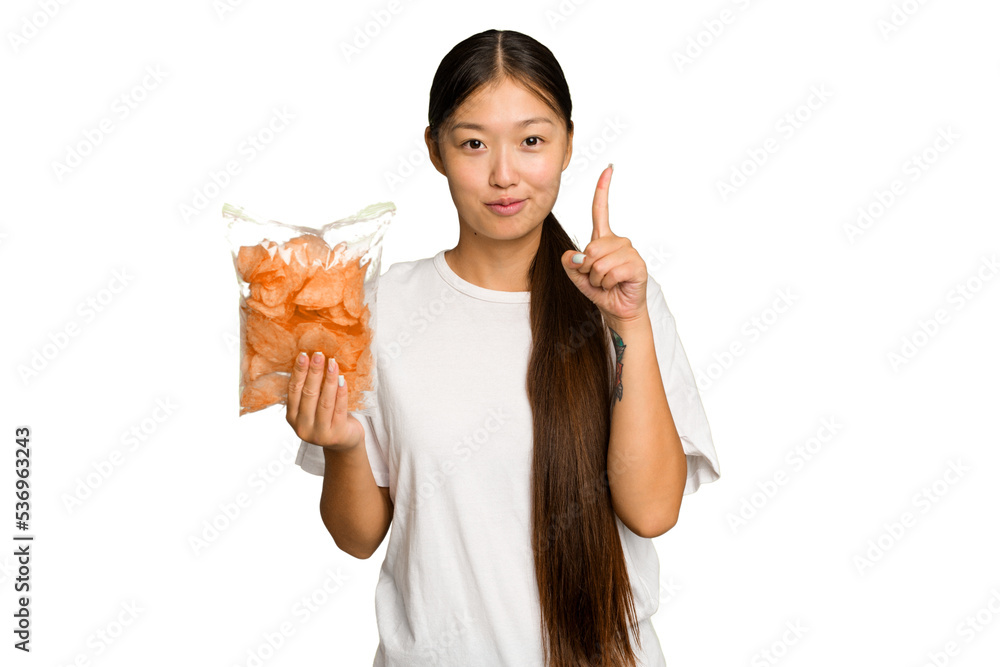 Young asian woman holding crips isolated on green chroma background showing number one with finger. Young asian woman holding crips isolated on green chroma background showing number one with finger.