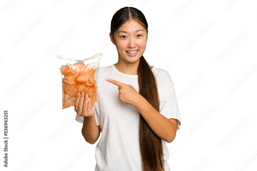 Young asian woman holding crips isolated on green chroma background smiling and pointing aside, showing something at blank space. Young asian woman holding crips isolated on green chroma background smiling and pointing aside, showing something at blank space.