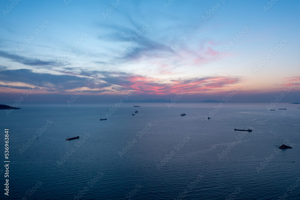 Sunset sky aerial photography with shoreline and ships on horizon top view