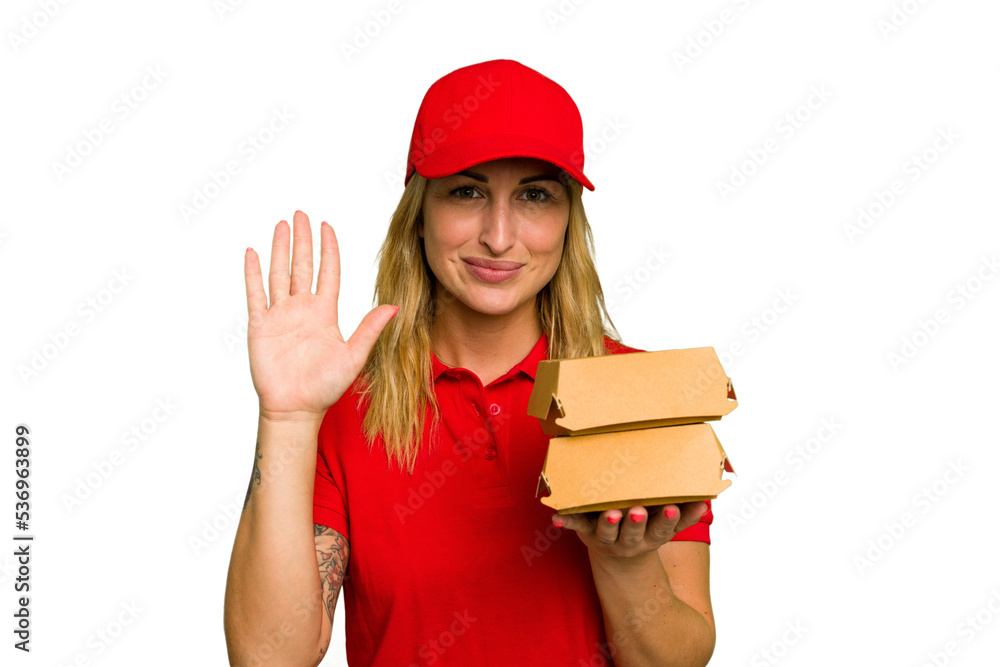 Young caucasian delivery woman holding a burger isolated on green chroma background smiling cheerful showing number five with fingers. Young caucasian delivery woman holding a burger isolated on green chroma background smiling cheerful showing number five with fingers.