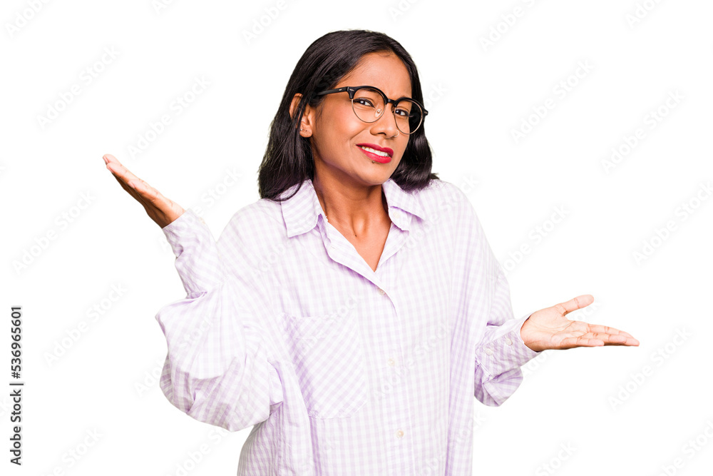 Young Indian woman isolated confused and doubtful shrugging shoulders to hold a copy space. Young Indian woman isolated confused and doubtful shrugging shoulders to hold a copy space.