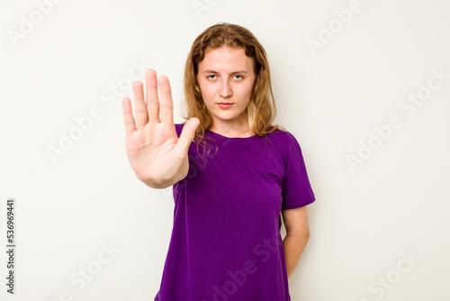 Young caucasian woman isolated on white background standing with outstretched hand showing stop sign, preventing you.