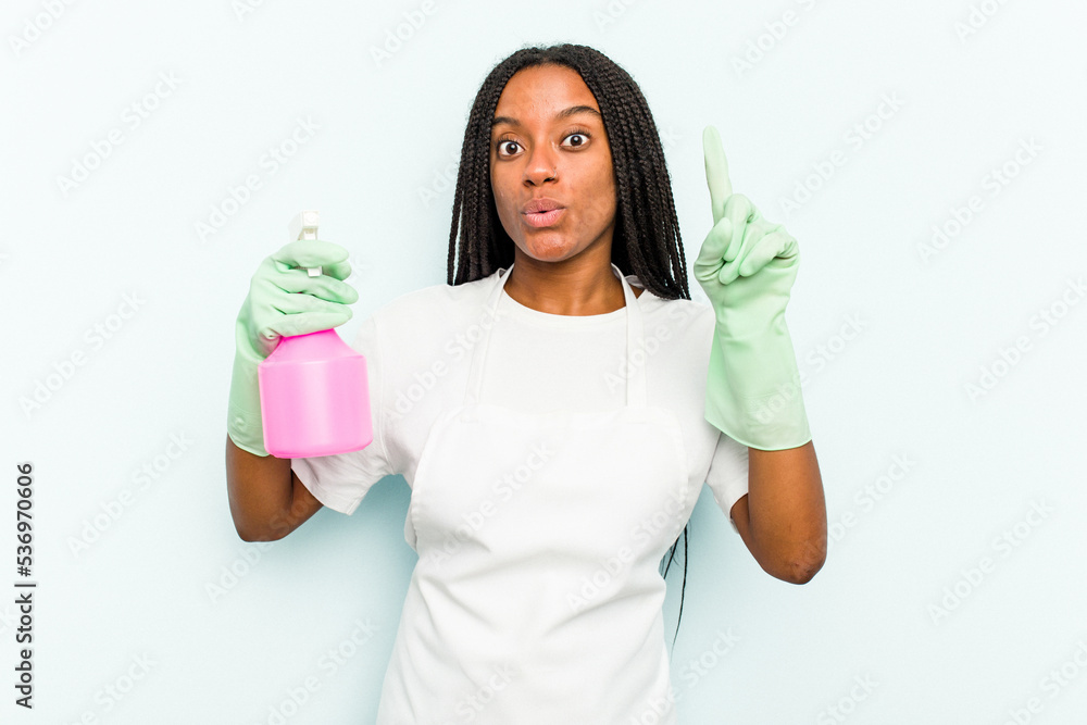 Young African American cleaner woman isolated on blue background having some great idea, concept of creativity. Young African American cleaner woman isolated on blue background having some great idea, concept of creativity.