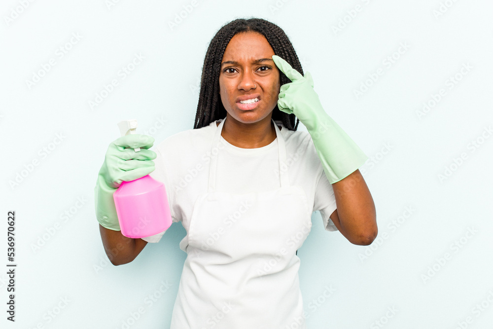 Young African American cleaner woman isolated on blue background showing a disappointment gesture with forefinger. Young African American cleaner woman isolated on blue background showing a disappointment gesture with forefinger.