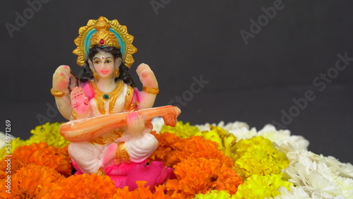 Sculpture of the goddess of wisdom Saraswati playing a stringed musical instrument.