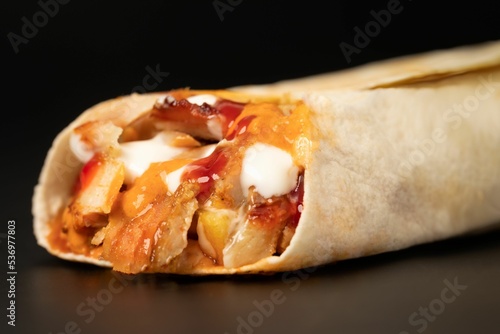 Closeup of delicious shawarma sandwich isolated in black background photo