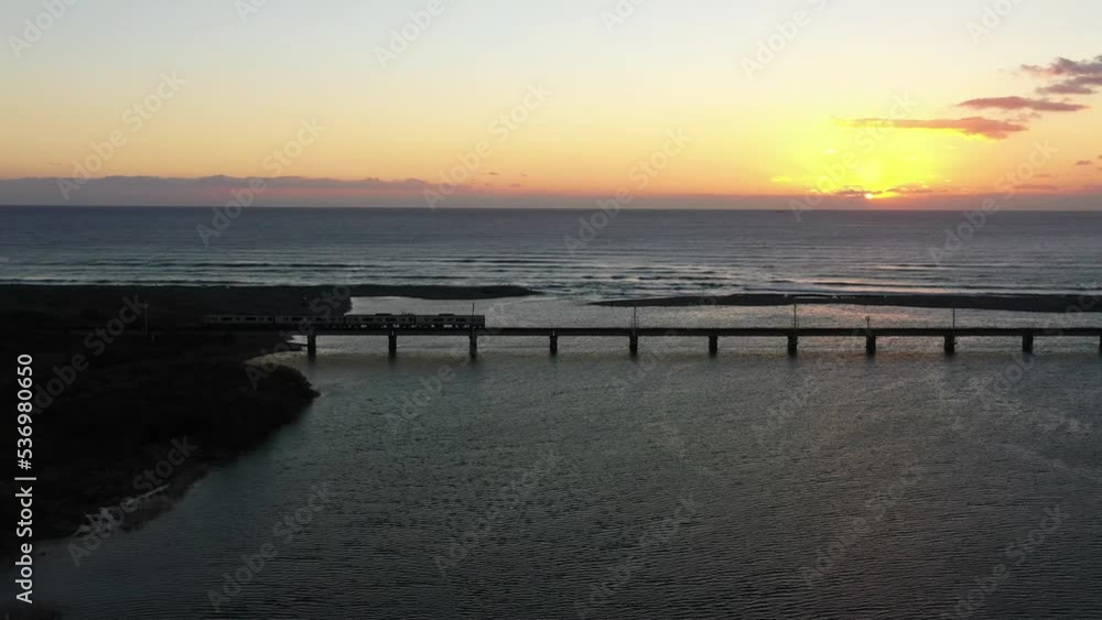 早朝の鉄橋を駆け抜ける特急列車