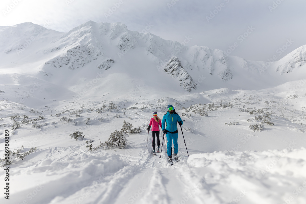 Ski touring couple hiking up a mountain in the Low Tatras in Slovakia.