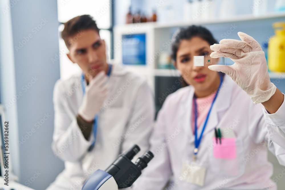 Man and woman scientists partners analysing sample at laboratory