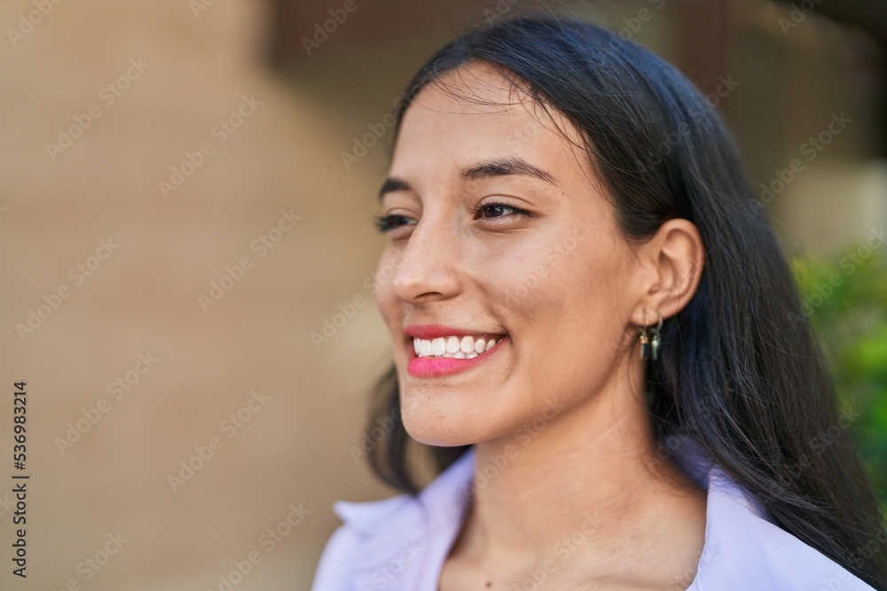 Young beautiful hispanic woman smiling confident looking to the side at street Young beautiful hispanic woman smiling confident looking to the side at street