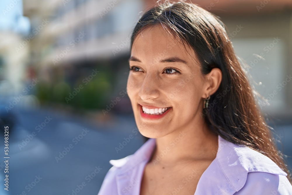 Young beautiful hispanic woman smiling confident looking to the side at street