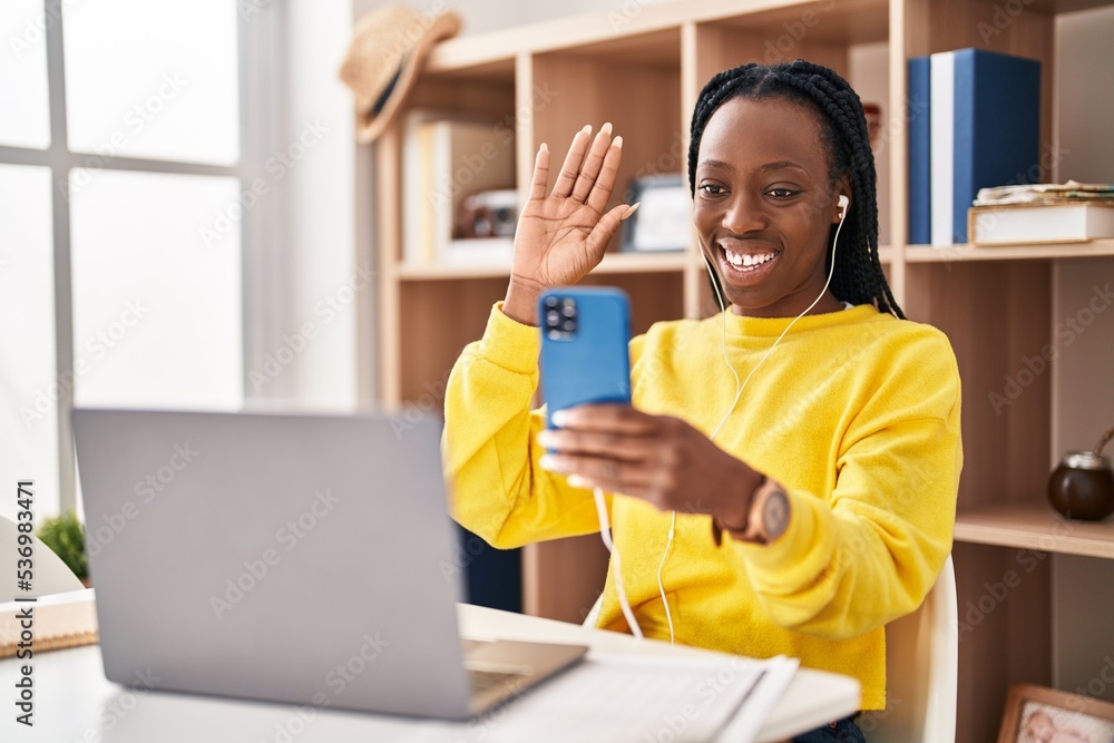 Beautiful black woman doing video call with smartphone looking positive and happy standing and smiling with a confident smile showing teeth Beautiful black woman doing video call with smartphone looking positive and happy standing and smiling with a confident smile showing teeth