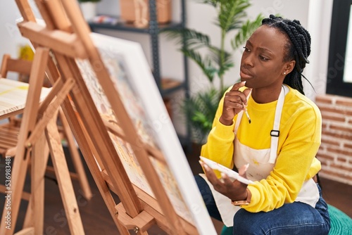 African american woman artist drawing with doubt expression at art studio