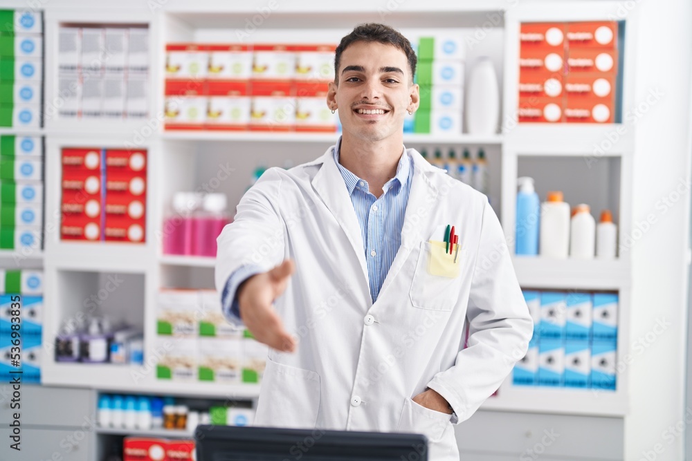Young hispanic man pharmacist smiling confident shake hand at pharmacy