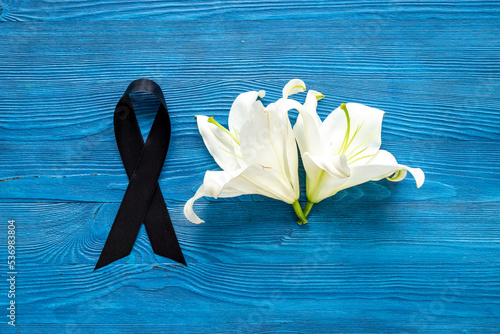 Mourning or funeral concept with white liles and black ribbon photo