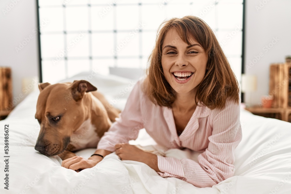 Young caucasian woman smiling confident lying on bed with dog at bedroom Young caucasian woman smiling confident lying on bed with dog at bedroom