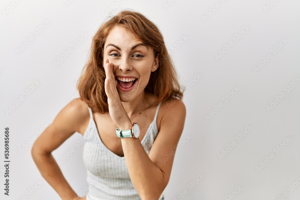 Fototapeta premium Beautiful caucasian woman standing over isolated background hand on mouth telling secret rumor, whispering malicious talk conversation