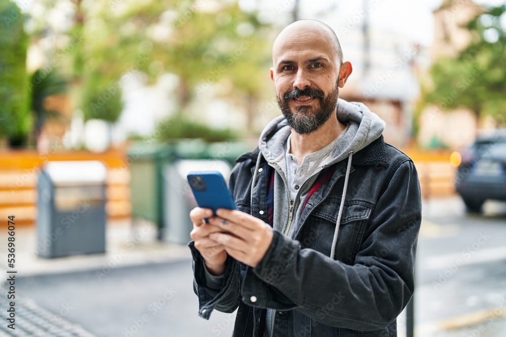 Young bald man smiling confident using smartphone at street Young bald man smiling confident using smartphone at street