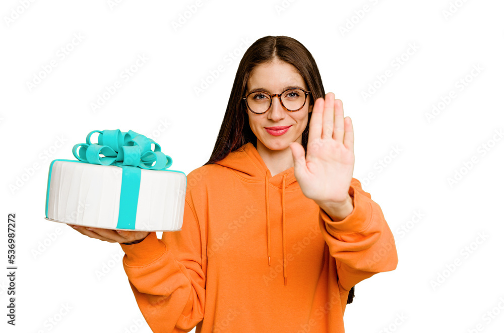 Young caucasian woman holding a birthday cake isolated standing with outstretched hand showing stop sign, preventing you. Young caucasian woman holding a birthday cake isolated standing with outstretched hand showing stop sign, preventing you.