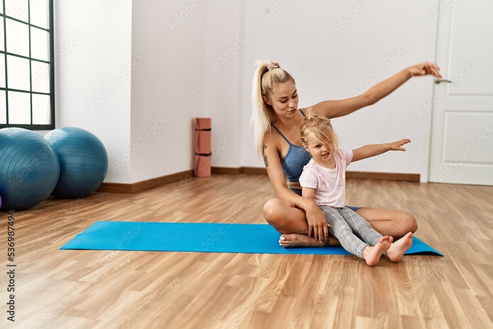 Mother and daughter smiling confident training yoga at sport center Mother and daughter smiling confident training yoga at sport center