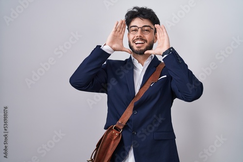 Hispanic man with beard wearing business clothes smiling cheerful playing peek a boo with hands showing face. surprised and exited