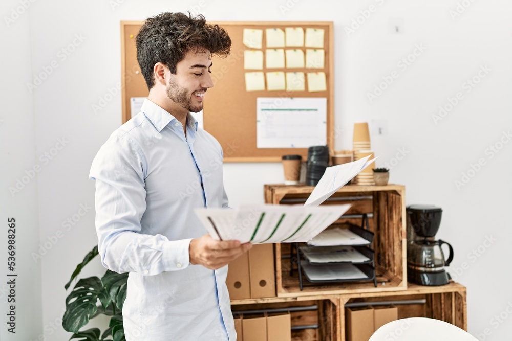 Young hispanic businessman smiling happy working at the office. Young hispanic businessman smiling happy working at the office.
