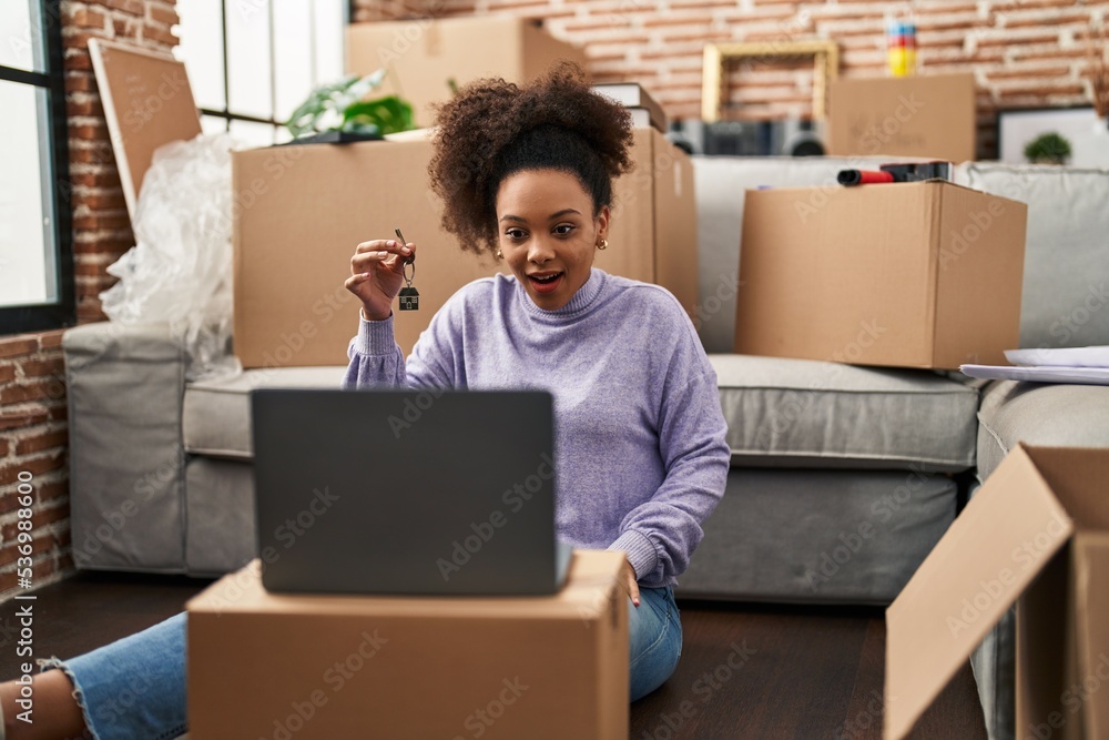 Young african american woman showing keys of new home on video call scared and amazed with open mouth for surprise, disbelief face Young african american woman showing keys of new home on video call scared and amazed with open mouth for surprise, disbelief face