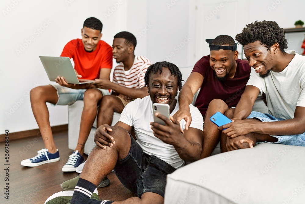 Group of african american people smiling happy using smartphone and laptop at home.