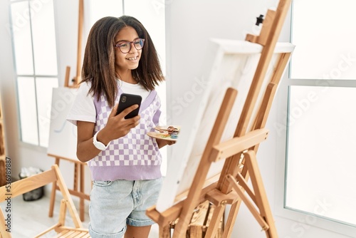 African american girl using smartphone drawing at art school
