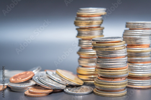 Stack of coins and heap coins on black table