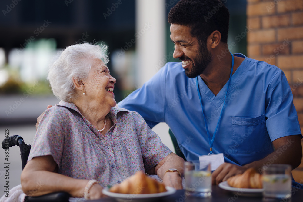 Caregiver having breakfast with his client at cafe. Caregiver having breakfast with his client at cafe.