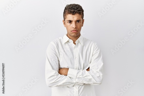 Young handsome hispanic man standing over isolated background skeptic and nervous, disapproving expression on face with crossed arms. negative person. © Krakenimages.com