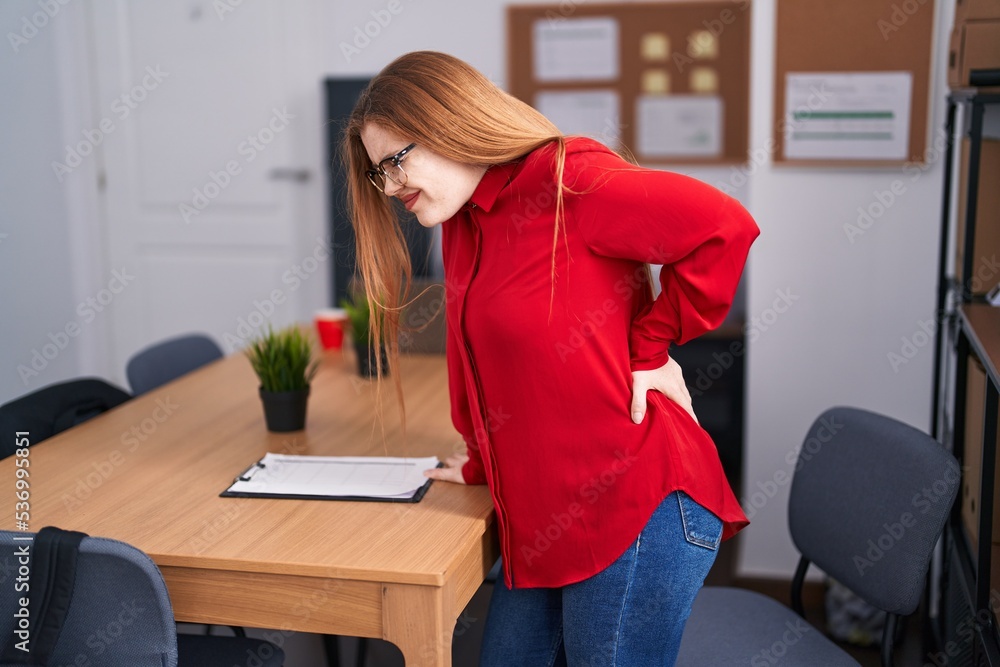 Young redhead woman business worker suffering for backache at office Young redhead woman business worker suffering for backache at office