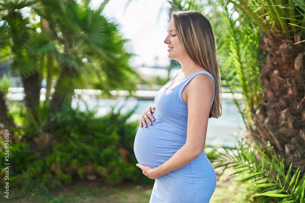 Young pregnant woman smiling confident touching belly at park Young pregnant woman smiling confident touching belly at park
