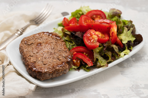 three fried ground meat with fresh salad on white plate