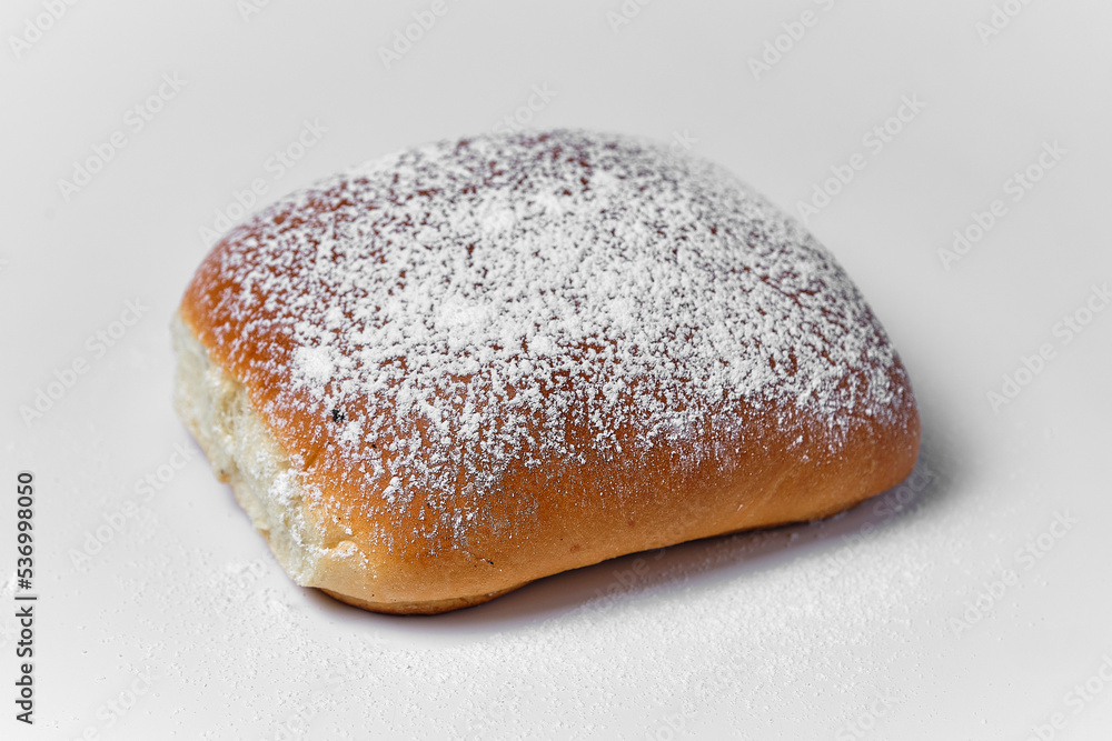 bun with powdered sugar on white background