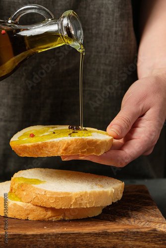 white bread with olive oil on a board on a black background
