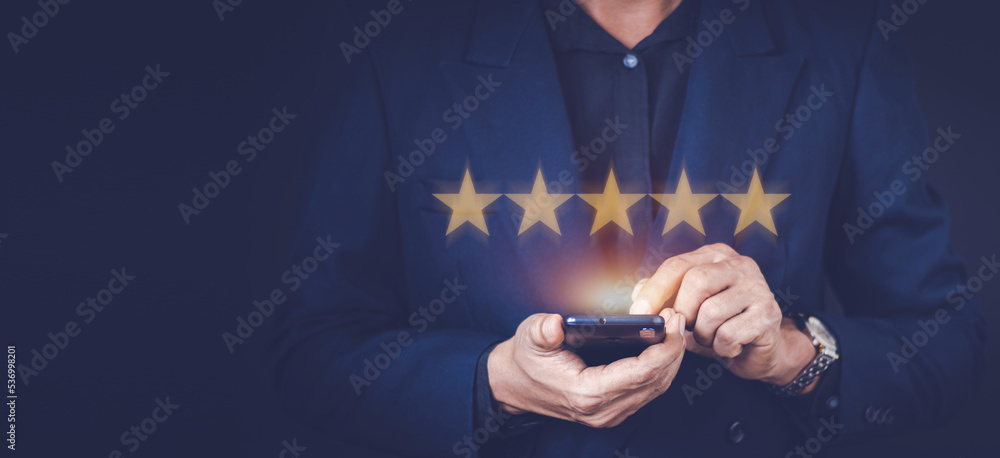 Man hand using smart phone and give five star symbol to increase rating of product and service concept, Customer service experience and business satisfaction survey.