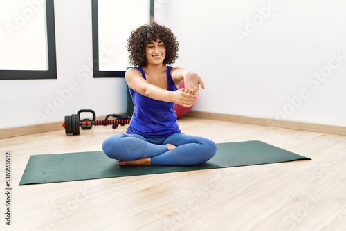 Young middle east woman smiling confident stretching at sport center