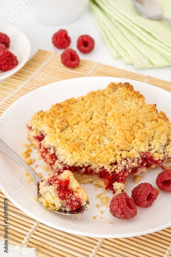 фотографія Portion of crumbly shortbread pie with raspberry on white plate
