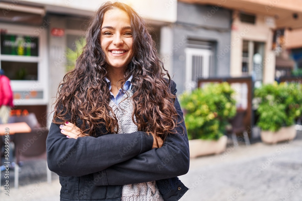 Young hispanic woman smiling confident standing with arms crossed gesture at street Young hispanic woman smiling confident standing with arms crossed gesture at street