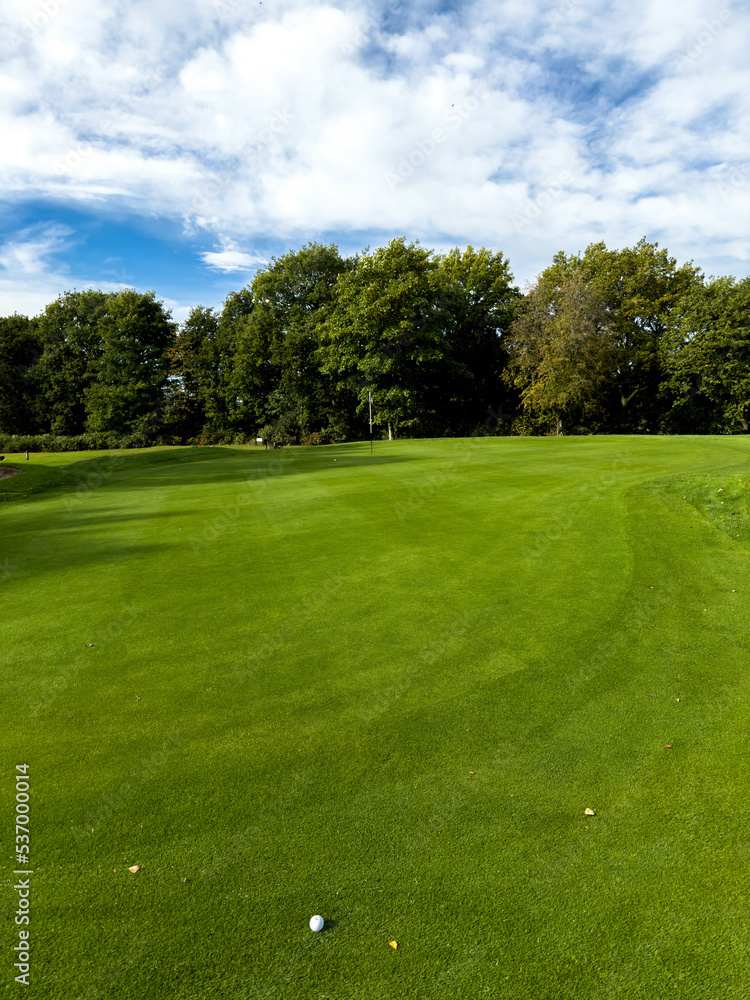 Golf course in the countryside with ball and flag in view Golf course in the countryside with ball and flag in view