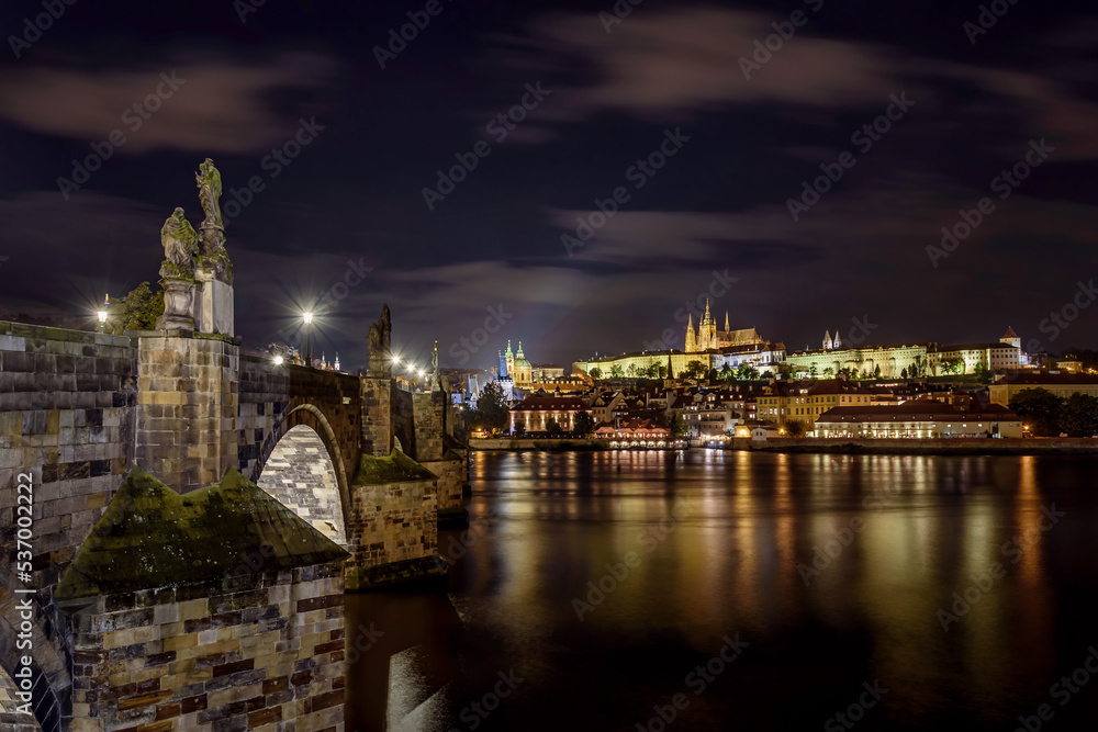The illuminated Charles Bridge and the Prague Castle with the Vltava River during the night.