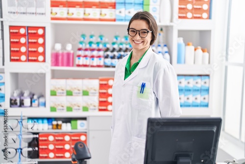 Young hispanic woman pharmacist smiling confident standing at pharmacy