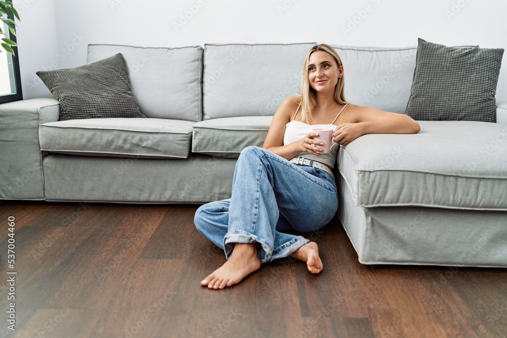Young blonde woman smiling confident drinking coffee at home Young blonde woman smiling confident drinking coffee at home