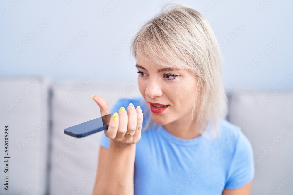 Young blonde woman talking on the smartphone sitting on sofa at home Young blonde woman talking on the smartphone sitting on sofa at home