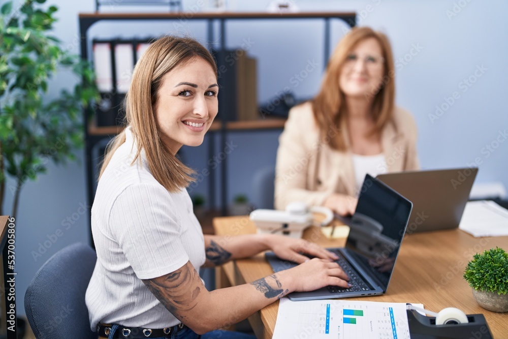 Mother and daughter business workers using laptop working at office Mother and daughter business workers using laptop working at office