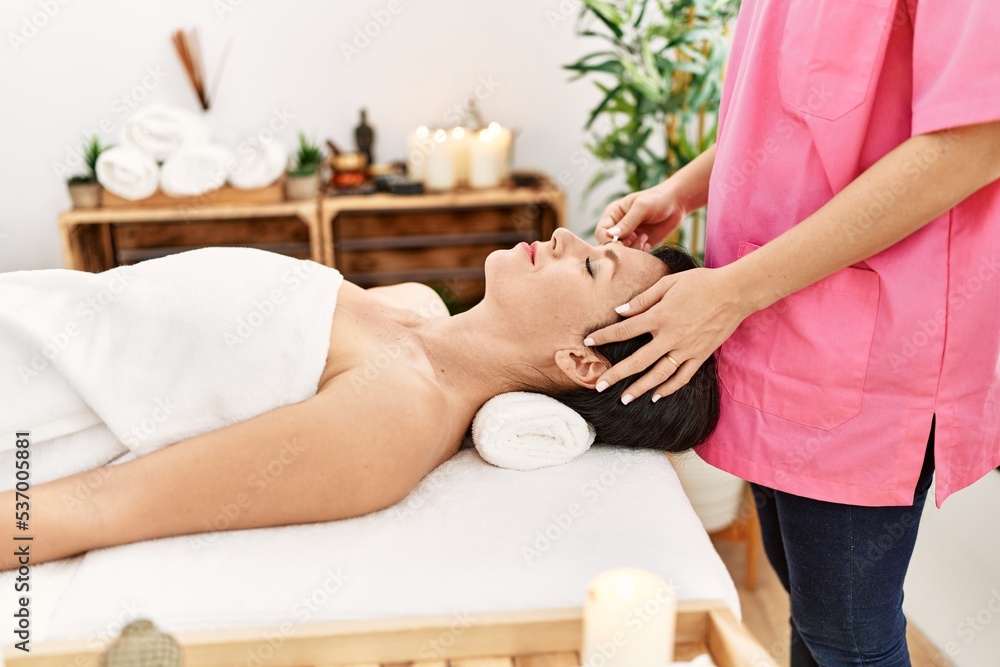 Middle age hispanic woman having eyebrows treatment at beauty center Middle age hispanic woman having eyebrows treatment at beauty center