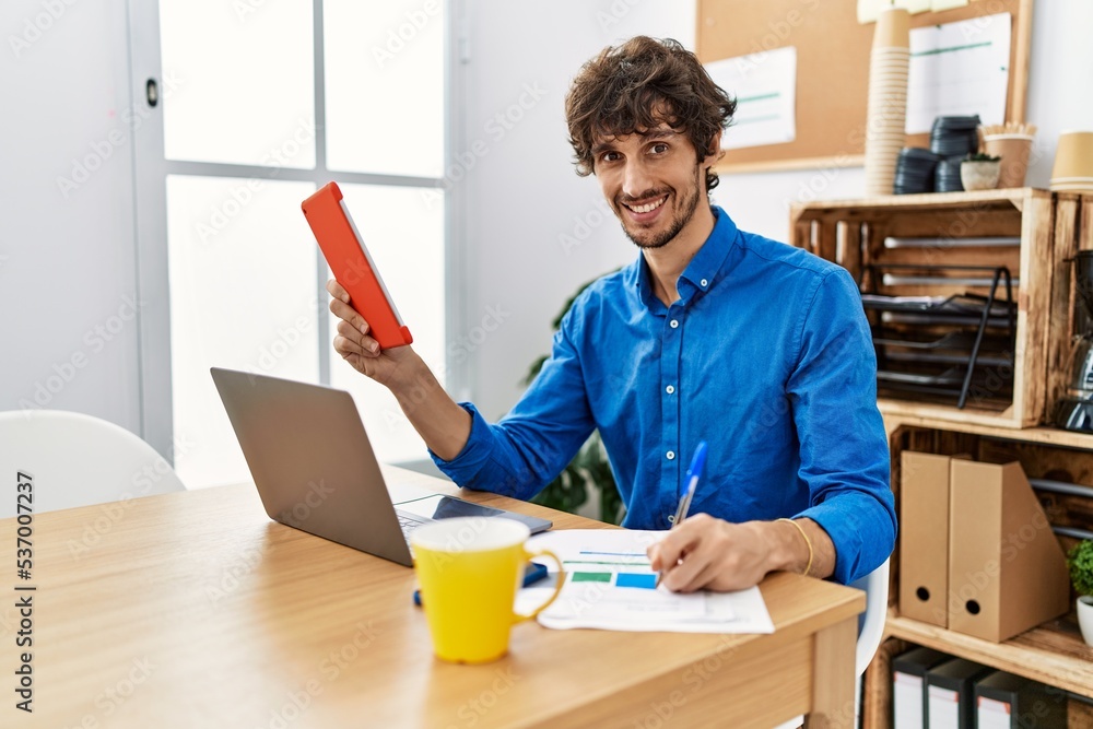 Young hispanic man using touchpad working at office Young hispanic man using touchpad working at office